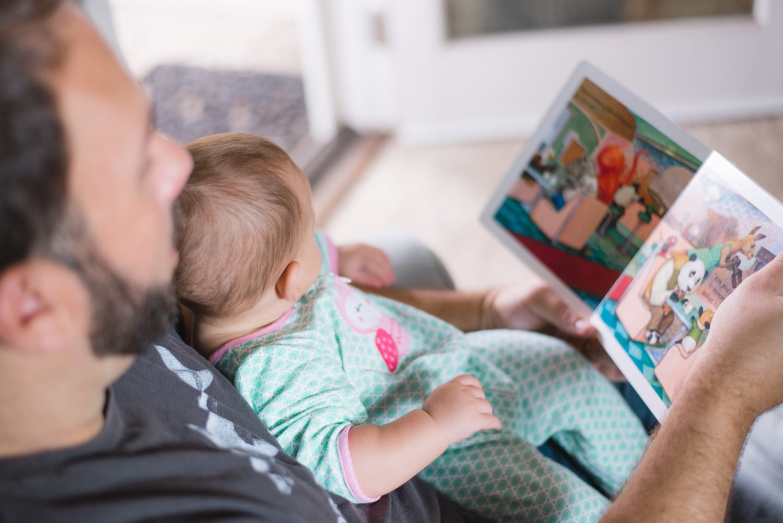 Man reads to child to introduce article by Kim Feeney, play therapist at Butterfly Beginnings Counseling