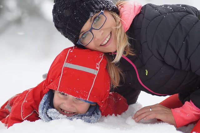 Child and parent playing in snow, building bonds with help from Butterfly Beginnings Counseling and Play Therapy