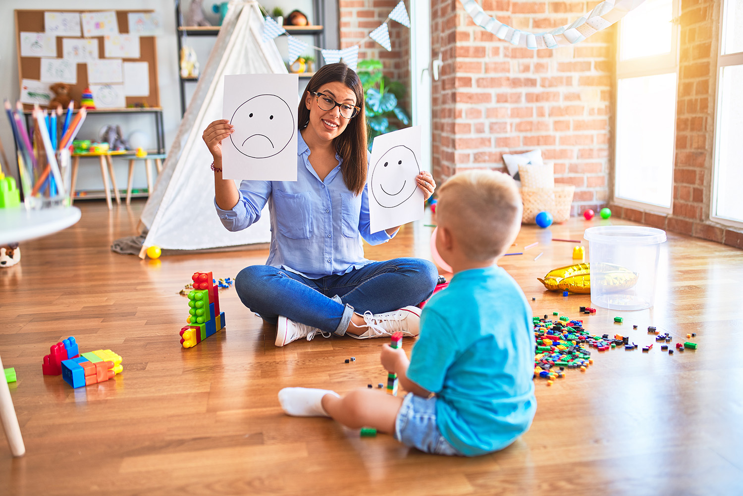 Butterfly Beginnings Counseling with Kim Feeney in Davenport Iowa answers why a Play Therapist can Help-image of therapist playing with child on floor