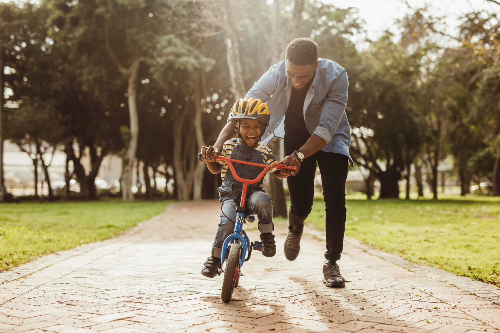 Father Encourages and Praises Son Riding a Bike at Butterfly Beginnings Play Therapy in Davenport, Iowa